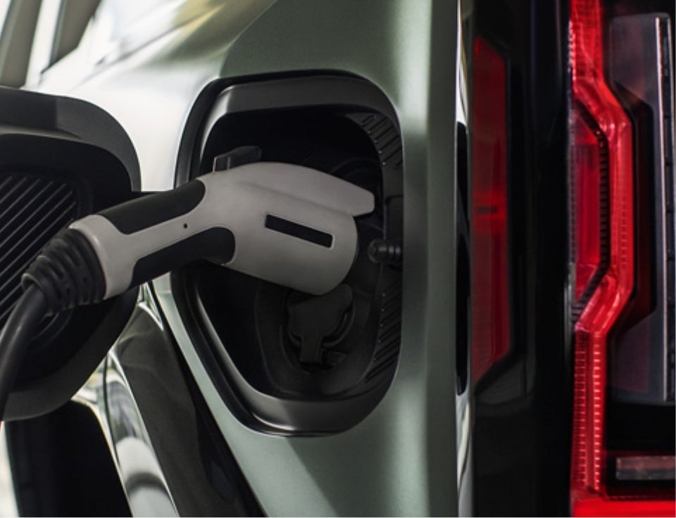 Close up of charging port with charger plugged in on a GMC Hummer EV SUV - Marquette GMC in MARQUETTE MI